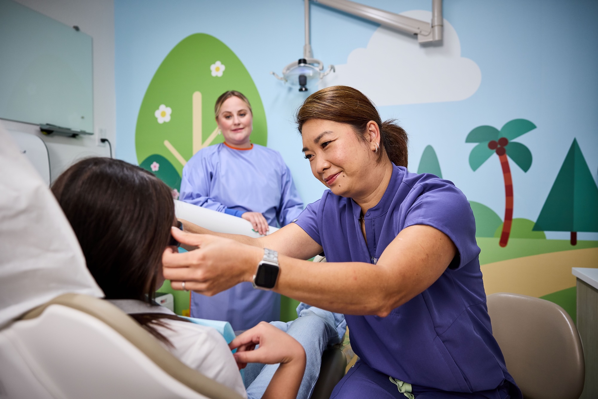A dentist putting sunglasses on a patient.