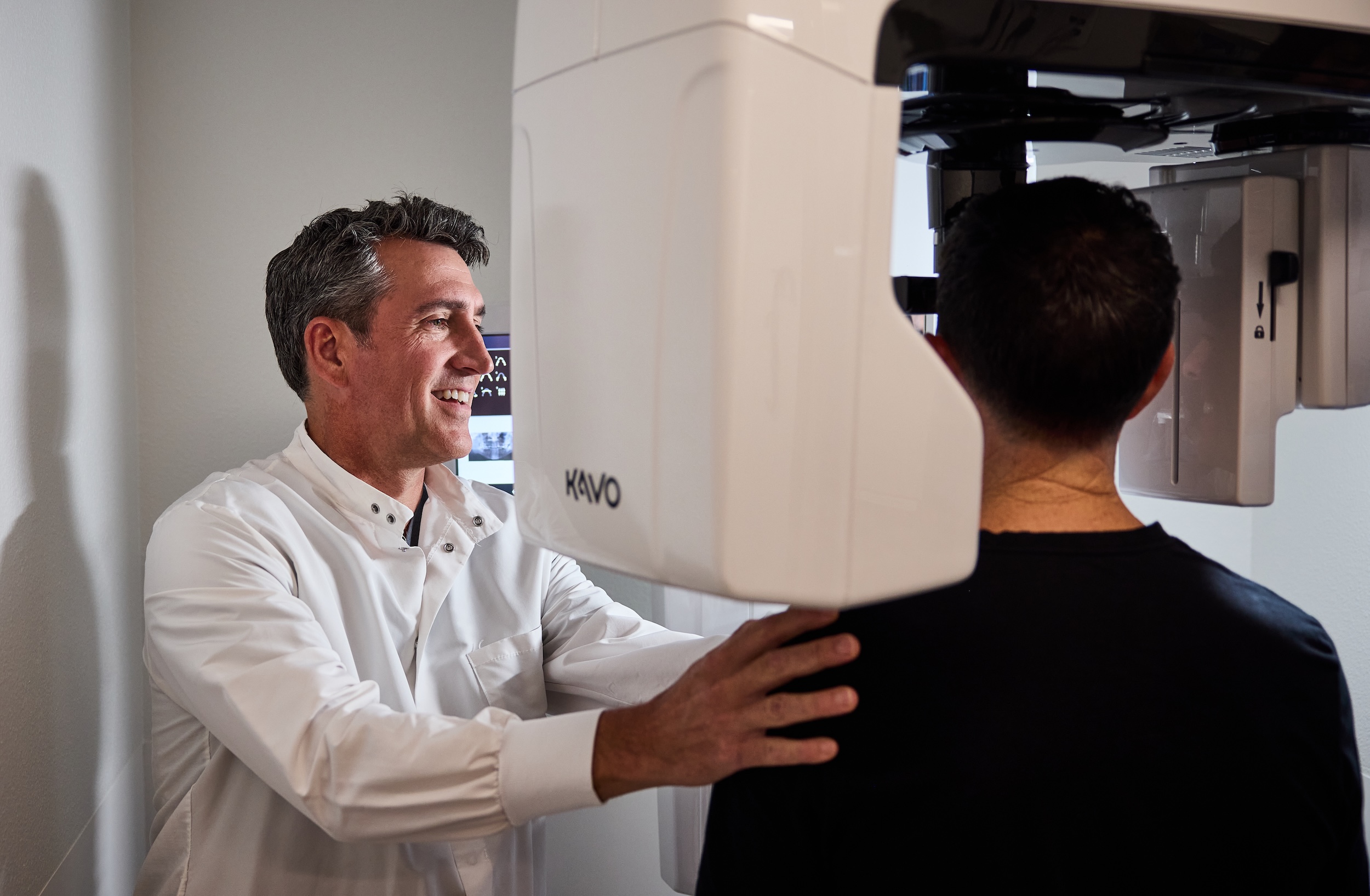 A doctor positioning a patient inside a 3D x-ray machine.